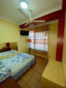 una camera con 2 letti e un ventilatore a soffitto di HOSPEDAJE Y TURISMO SOL & LUNA E.I.R.L a Tarapoto