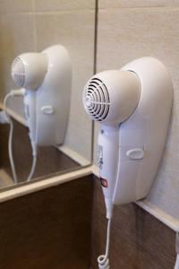 a hair dryer hanging on a wall in a bathroom at Estancia Yolanda C1-C3 8Pax - By Inside in Ciudad Lujan de Cuyo