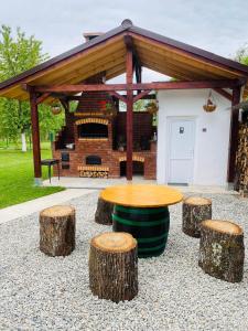 a picnic shelter with a table and three logs at Serenity Garden Villa in Runcu