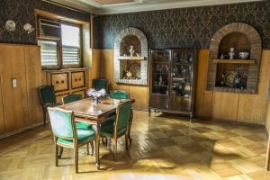 a dining room with a wooden table and green chairs at Guest House Top Floor in Telavi