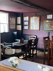 een eetkamer met een tafel en stoelen bij The George Inn in Windsor