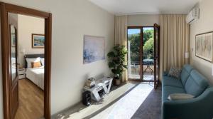 ein Wohnzimmer mit einem blauen Sofa und ein Schlafzimmer in der Unterkunft Adria Montenegro Seaview in Herceg-Novi
