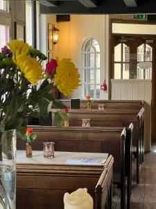 a row of pews in a church with flowers in a vase at The George Inn in Windsor