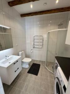 y baño con lavamanos y lavadora. en Innerstan nya lägenheter Södramurgatan 45b, en Visby