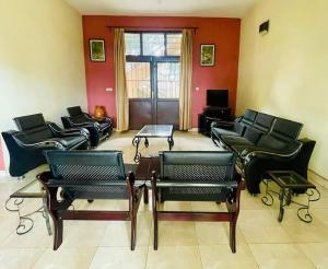 sala de estar con sofás de cuero y mesa en Oasis Urbaine 3 Chambres, Mixte, en Buyumbura