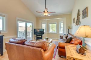 a living room with leather furniture and a flat screen tv at Lake-View Condo with Covered Deck in Hiawassee! in Hiawassee