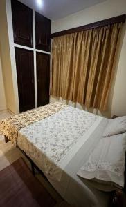 a bedroom with a bed in front of a window at Oasis Urbaine 3 Chambres, Mixte in Bujumbura