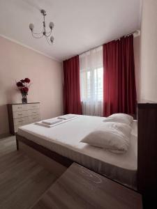 a bedroom with a large bed with a red curtain at 215 Рядом с Байтереком для 1-5 чел с 2 большими кроватями и диваном in Astana