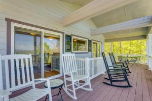 a porch with rocking chairs and a table at Lake-View Condo with Covered Deck in Hiawassee! in Hiawassee