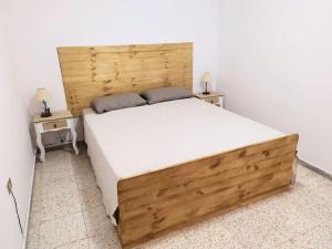 a bedroom with a large wooden bed with two tables at Casa terrera de 2 dormitorios en Fasnia in Fasnia