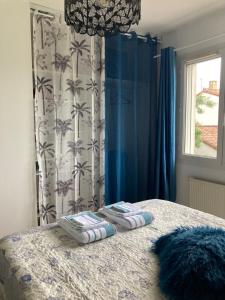 a bedroom with a bed with blue curtains and a window at Villa Rose Suite et chambres chez l'habitant in Montpellier +25 photos