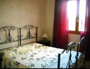 um quarto com uma cama com colcha floral e uma janela em Tranquilla e silenziosa casa in campagna em Valverde