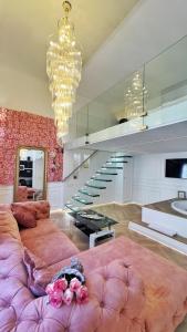 a living room with a large pink couch and stairs at Jacuzzi Opera Suite in Budapest