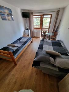 1 dormitorio con 2 camas y mesa. en Pensjonat pod Dębami en Pobierowo