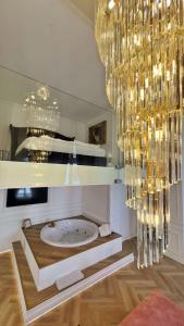 a bathroom with a tub with a chandelier at Jacuzzi Opera Suite in Budapest