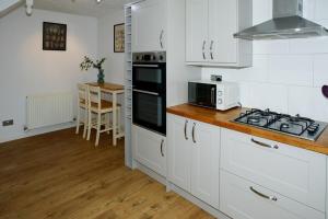 uma cozinha com armários brancos e um forno com placa de fogão em Amazing City Location-close To River- Large Home em Chesterton