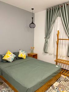a bedroom with a green bed and a window at Gallery homestay in Quy Nhon