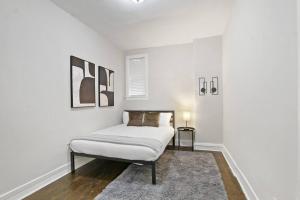 Habitación blanca con cama y alfombra en 3BR Vibrant Apartment in Hyde Park - Bstone 5310-1 en Chicago
