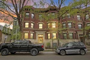 3BR Vibrant Apartment in Hyde Park - Bstone 5310-1 في شيكاغو: شاحنة سوداء وسيارة متوقفة أمام مبنى