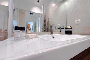 Baño blanco con lavabo y espejo en St Roch 2 - Appart 300 m de la Gare, clim, terrasse, garage, en Antibes