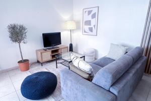 sala de estar con sofá azul y TV en St Roch 2 - Appart 300 m de la Gare, clim, terrasse, garage en Antibes