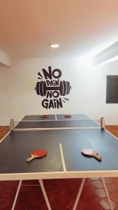 tavolo da ping pong in una stanza con un cartello sul muro di Hotel Boutique Casa & Cava a Mendoza