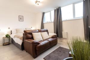 a bedroom with a couch and a bed with windows at June Disc - Long Stay - Contractors in Swindon