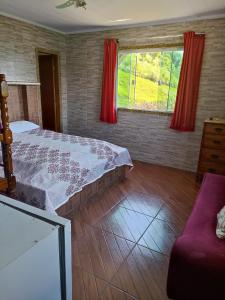 sypialnia z łóżkiem i dużym oknem w obiekcie Pousada Linda Vista w mieście Domingos Martins