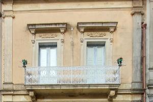 - un balcon sur le côté d'un bâtiment avec deux fenêtres dans l'établissement Antica Via delle Aie, à Ruffano