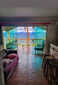 a living room with a large glass door with a view at Pousada Linda Vista in Domingos Martins