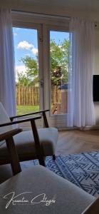 a living room with a chair and a large window at Wellness cottage met hottub 'Auckland' by Kawatea in Ewijk