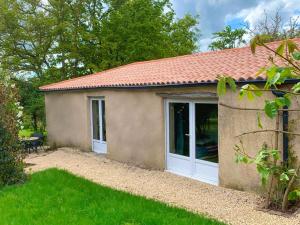 a small house with a large sliding door at Le Clos des Écorcins - Terrasse - Parking privé in Saint-Amand-sur-Sèvre