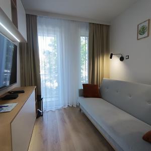 a living room with a couch and a large window at Ama Molto Apartments in Wrocław