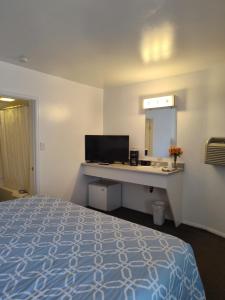 a hotel room with a bed and a desk with a mirror at Colorado Inn Motel in Canon City