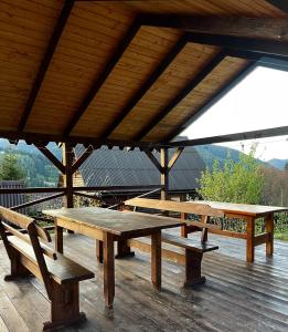 un gruppo di tavoli da picnic e panche su una terrazza di Khatky Na Penkakh a Vorokhta