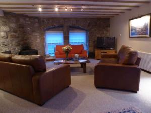 - un salon avec deux canapés et une télévision dans l'établissement Craigruie Farmhouse, à Balquhidder