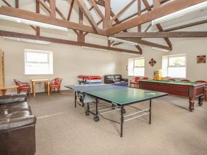 a room with a ping pong table and chairs at Valley Lodge 55 in Callington