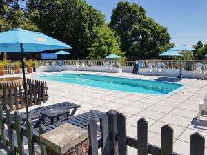 a swimming pool with two chairs and an umbrella at Valley Lodge 55 in Callington