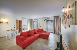 - un salon avec un canapé rouge et une table dans l'établissement La casa di Cinzia central apartment, à Lierna