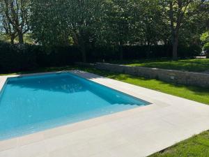 una piscina en un patio con una pared de piedra en Espectacular Casa Chateau en el centro de Olot en Olot
