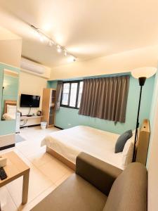 um quarto com uma cama grande e um sofá em 一中小窩馨 em Taichung