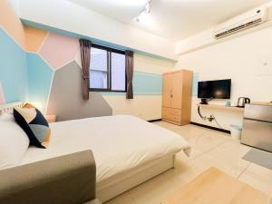 um quarto com uma cama e uma televisão em 一中小窩馨 em Taichung