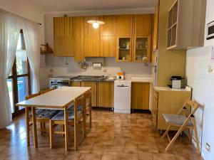 a kitchen with wooden cabinets and a table with chairs at La Luna sul lago in Trevignano Romano
