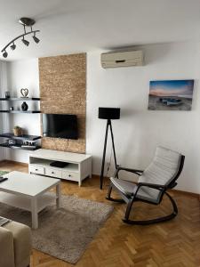 a living room with a chair and a television at City apartment with the sea view in Bar