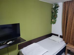 a small room with a bed and a flat screen tv at Solar in Plovdiv