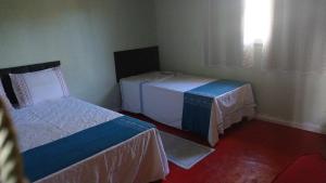 una camera d'albergo con due letti e una finestra di Maria Bonita Eco Pousada a Diamantina