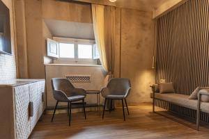 een kamer met 2 stoelen en een tafel en een bed bij LE RÊVE DE NAIM in Florence