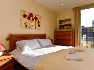 Un dormitorio con una gran cama blanca con ventana. en Pass the Keys Perfectly Located Apartment, en Cardiff