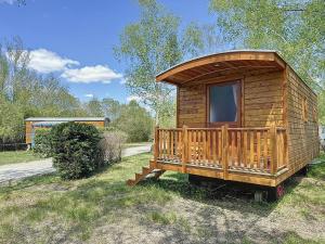 una cabina in legno con finestra sull'erba di FLOR La Roulotte du Médoc a Naujac-sur-Mer