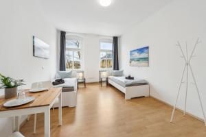 sala de estar con paredes blancas y mesa en home2stay Apartmenthaus Halle Zentrum Parking,Kitchen,Wifi ***, en Halle an der Saale